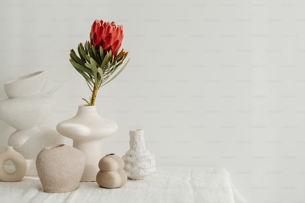 花でいっぱいの花瓶で覆われた白いテーブル