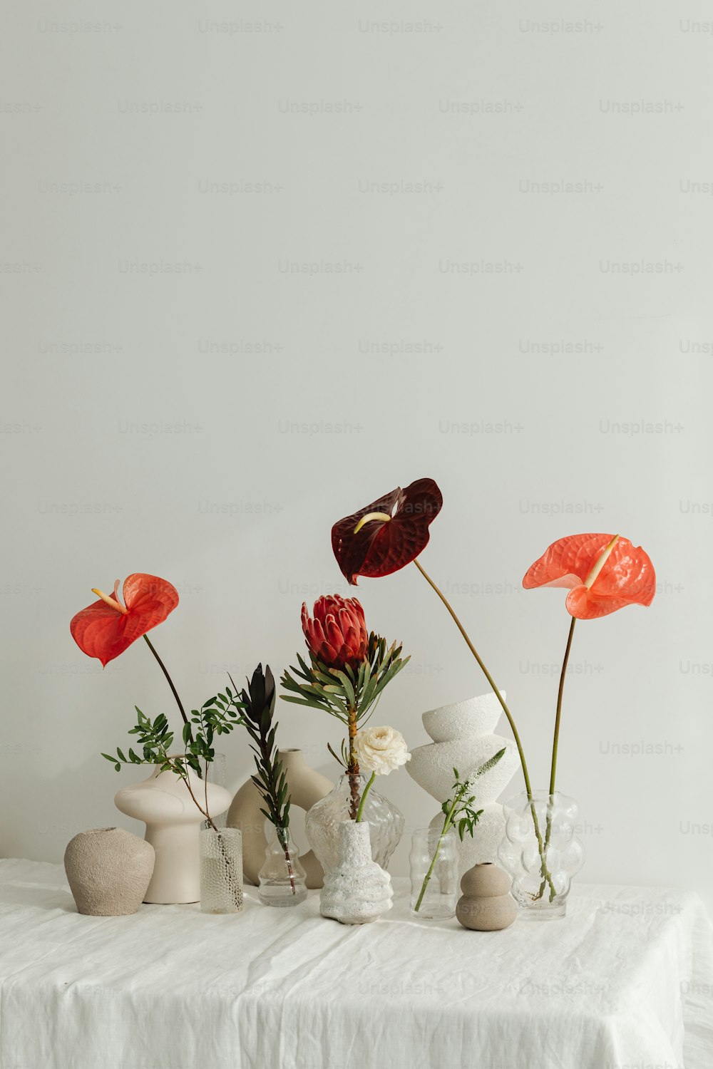 uma mesa branca coberta com vasos cheios de flores
