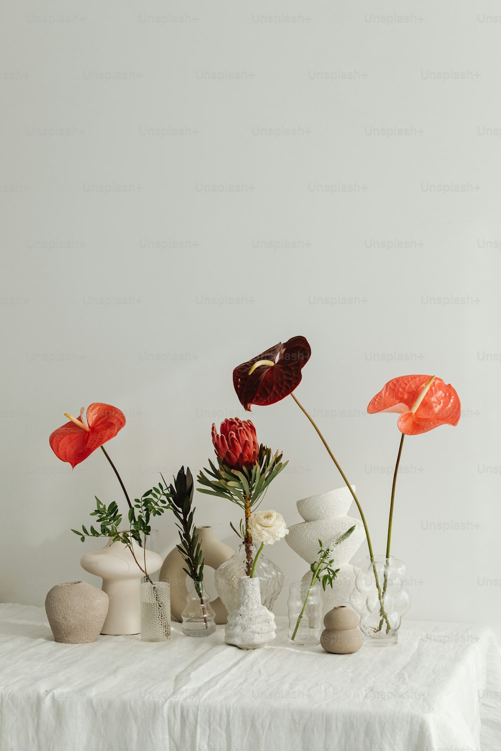 a white table topped with vases filled with flowers