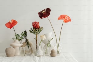 Una mesa blanca cubierta con jarrones llenos de flores