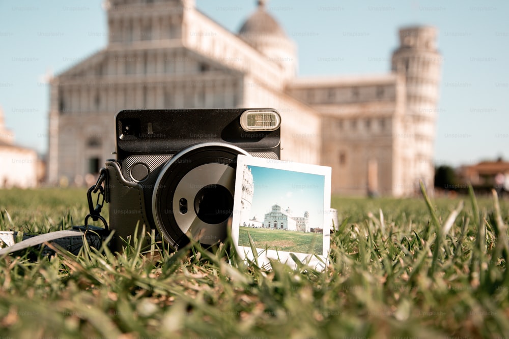 a camera sitting on top of a lush green field