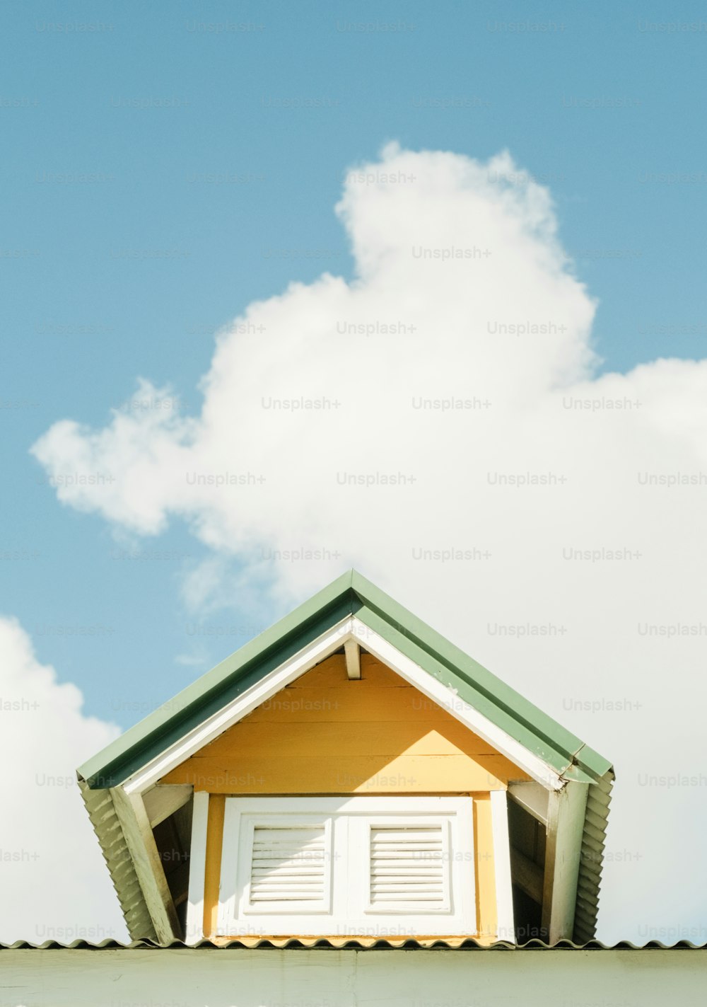 a house with a green roof and white shutters