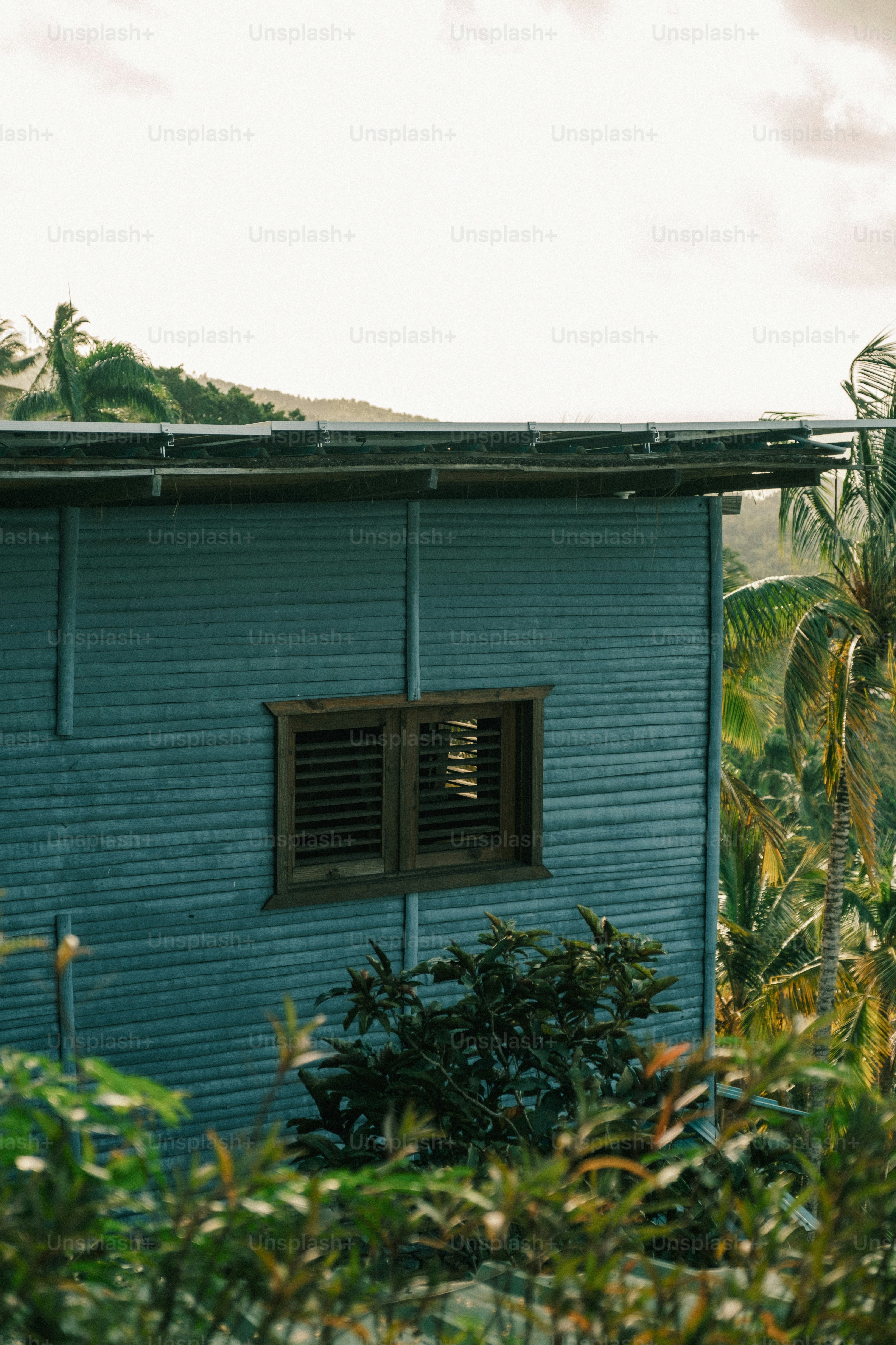 a blue building with a window and a roof