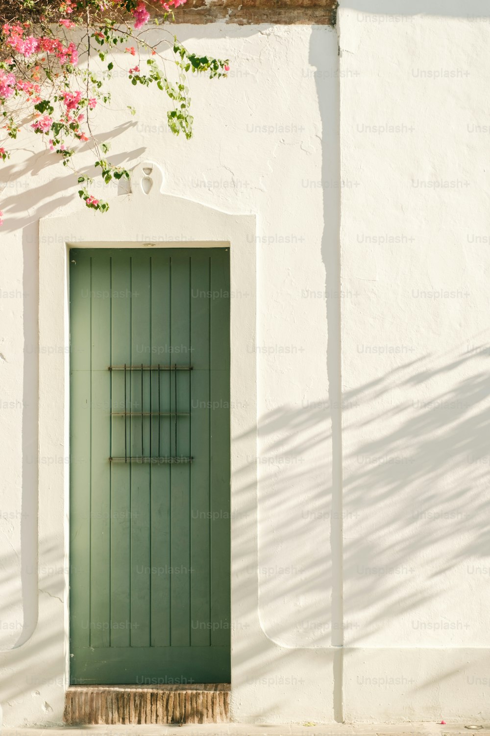 a green door on the side of a white building