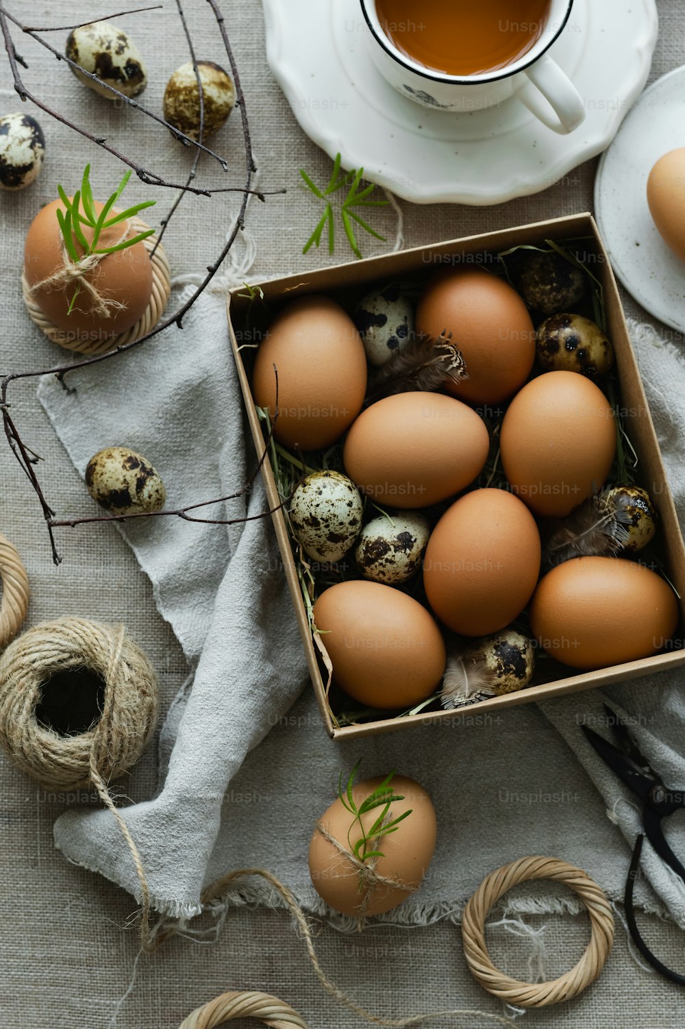 a box of eggs sitting next to a cup of tea