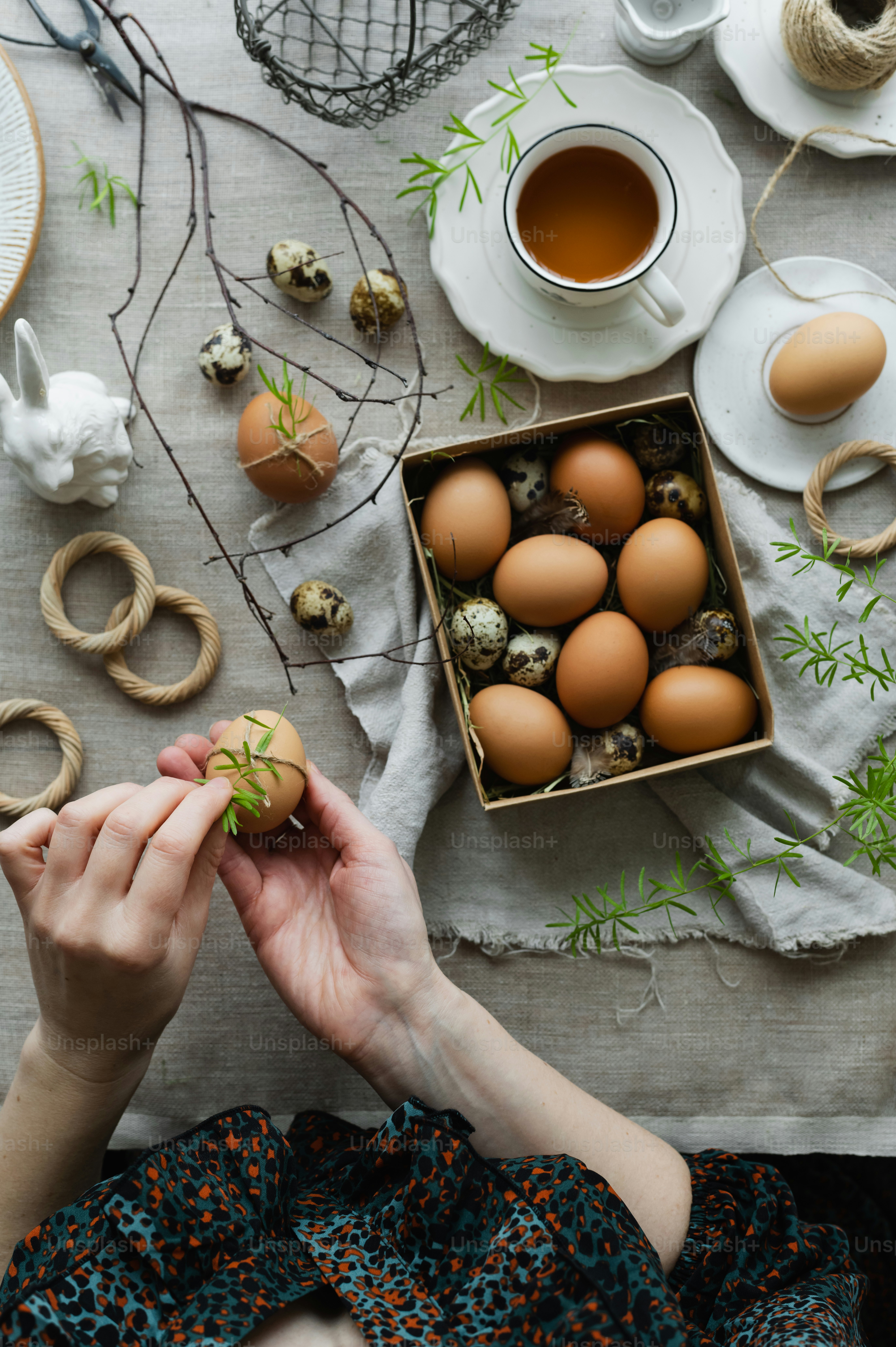a woman holding a piece of food next to a box of eggs