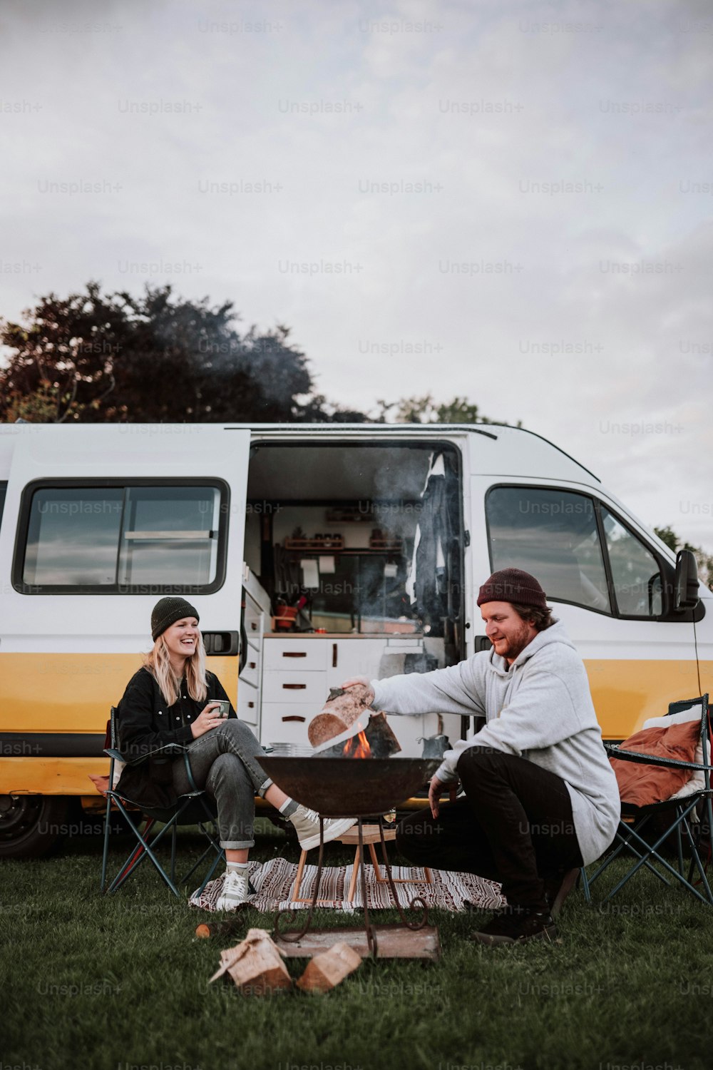 um homem e uma mulher sentados em uma mesa na frente de uma van