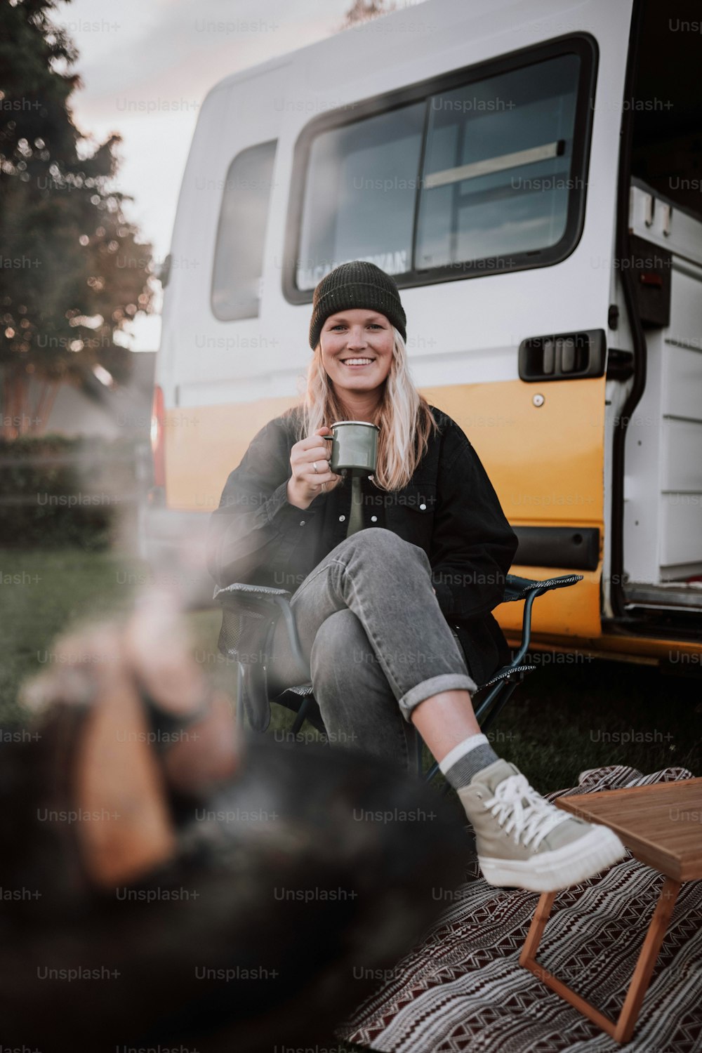 a woman sitting in a chair holding a cup of coffee