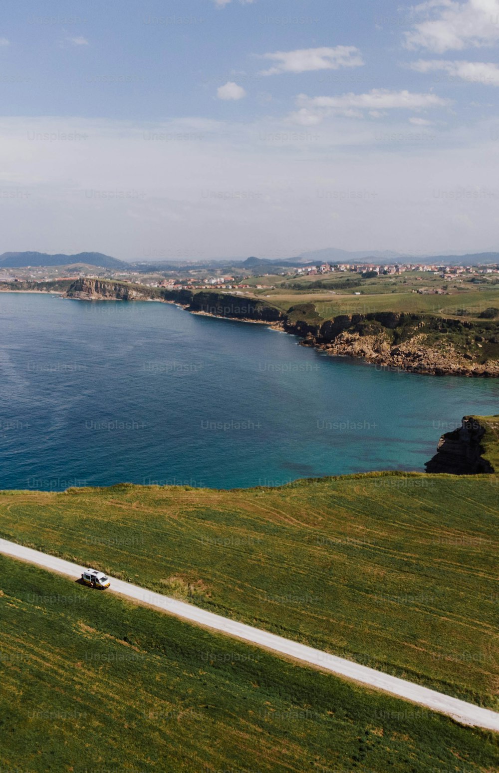 a car driving down a road next to a body of water