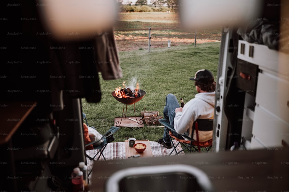 a man sitting in a chair next to a fire pit