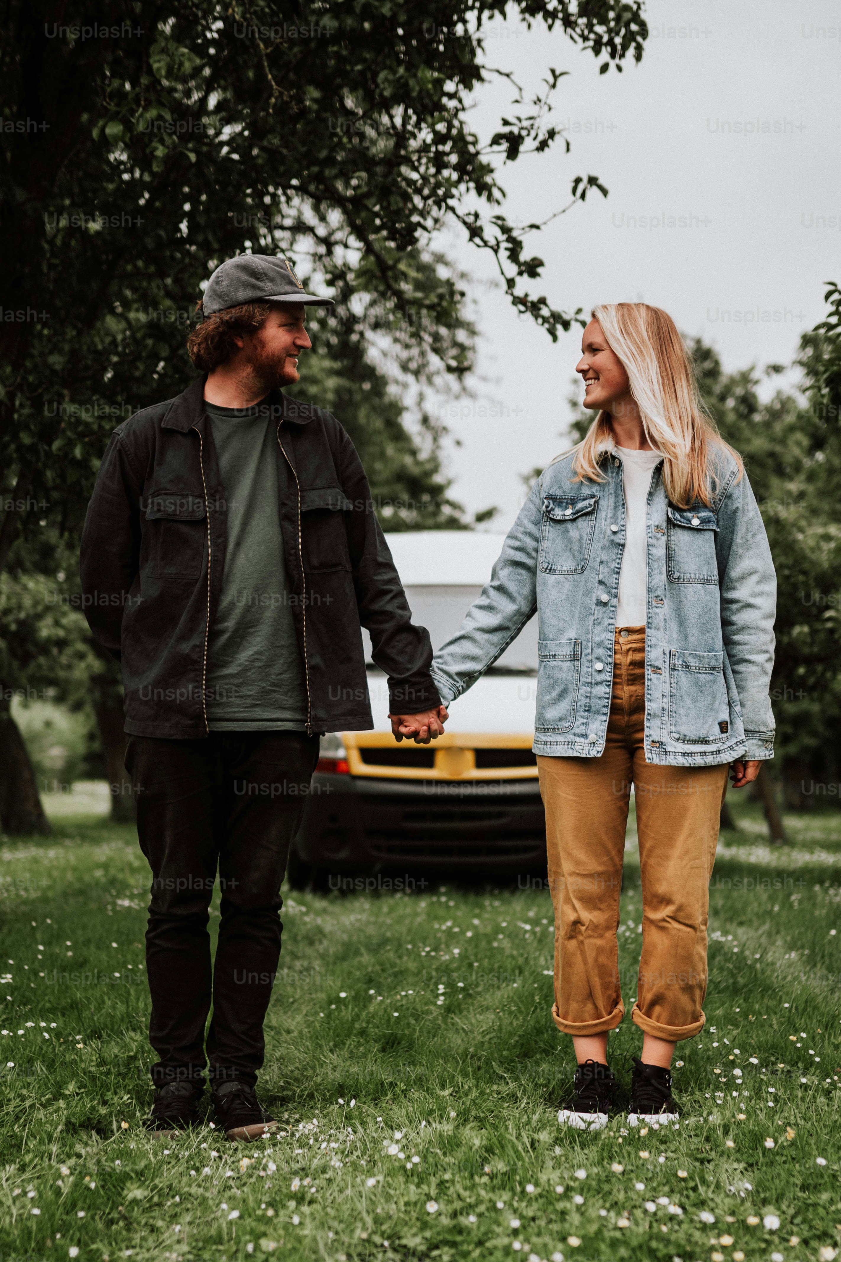 Ein Mann und eine Frau halten sich Händchen im Gras