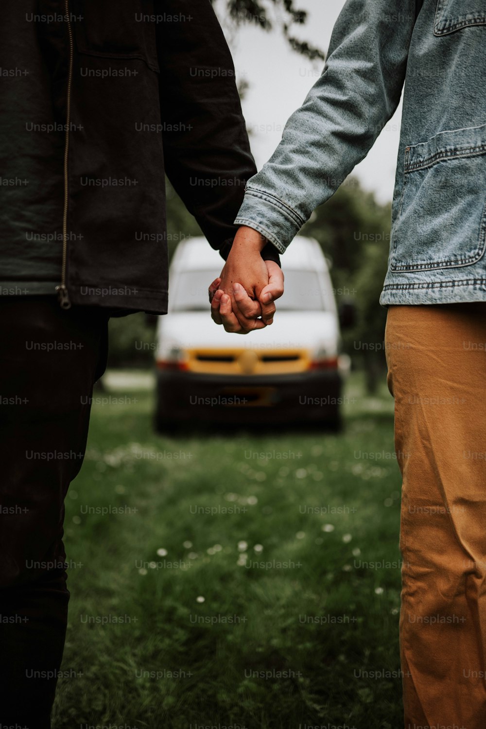 two people holding hands in front of a car