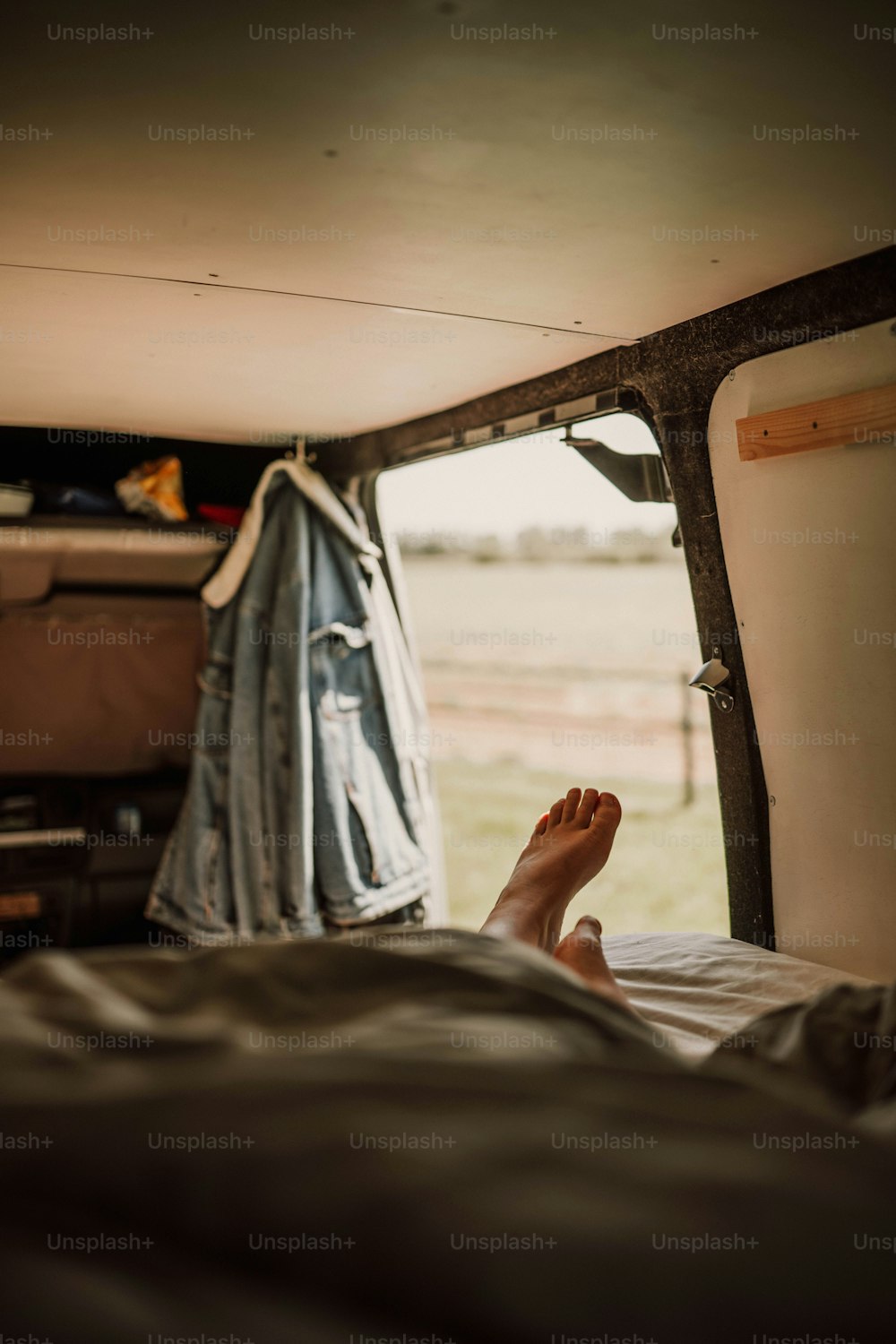 Die Füße einer Person ragen aus der Ladefläche eines Lastwagens