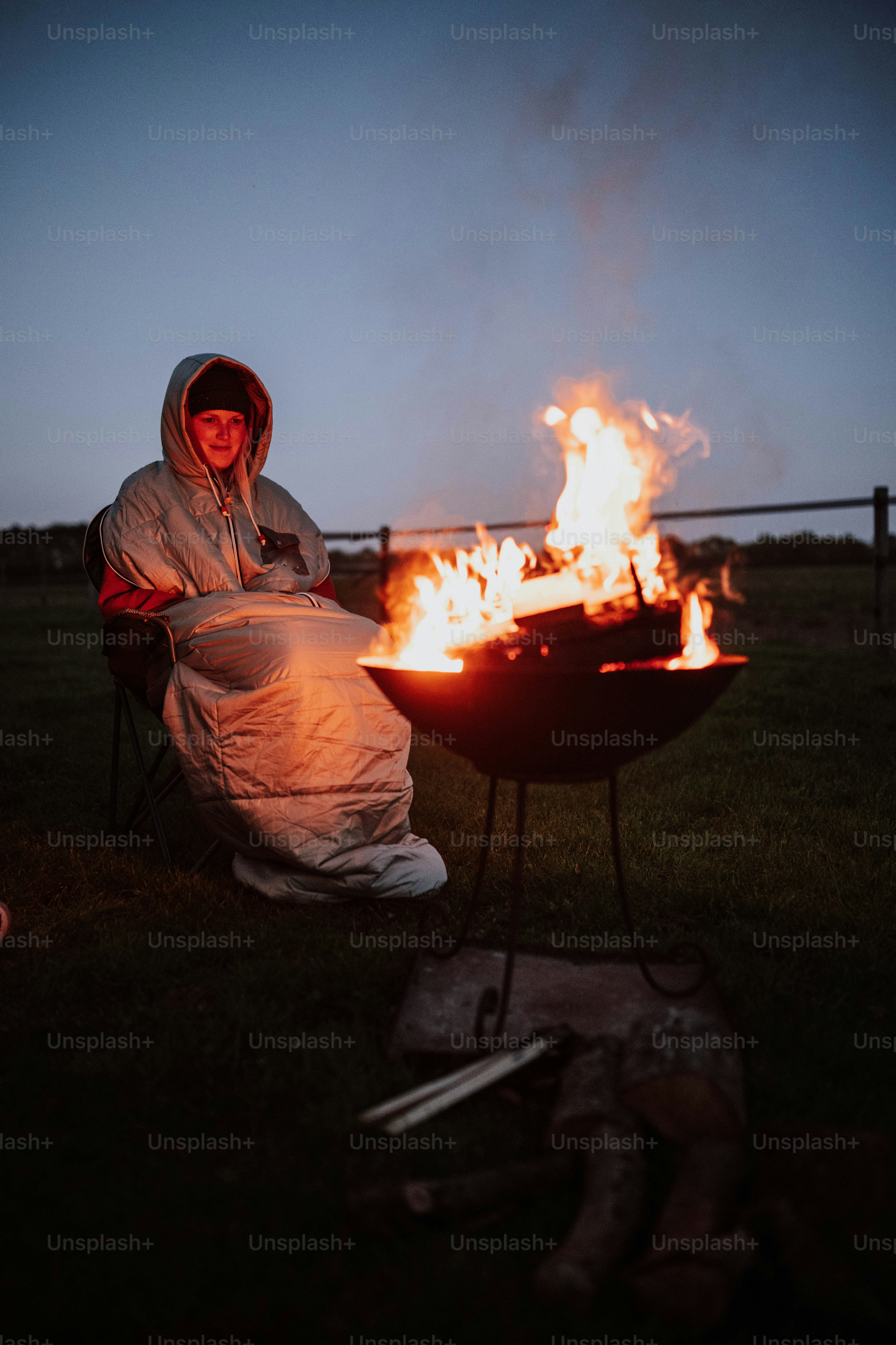 a man sitting in a chair next to a fire pit