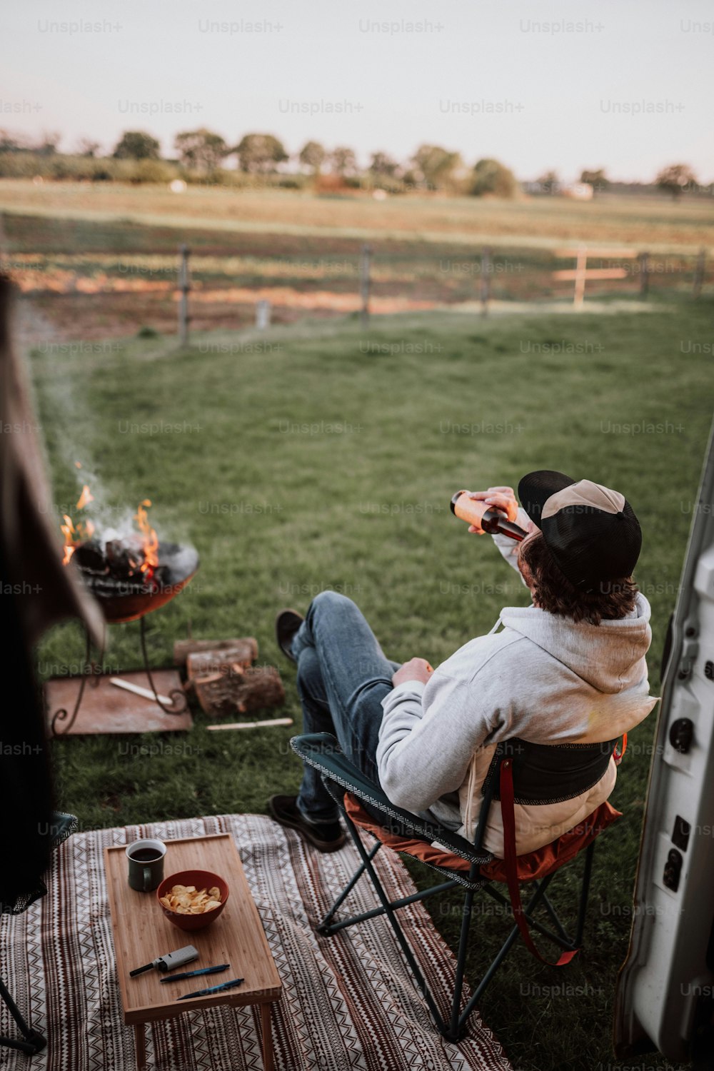 a man sitting in a chair next to a fire pit