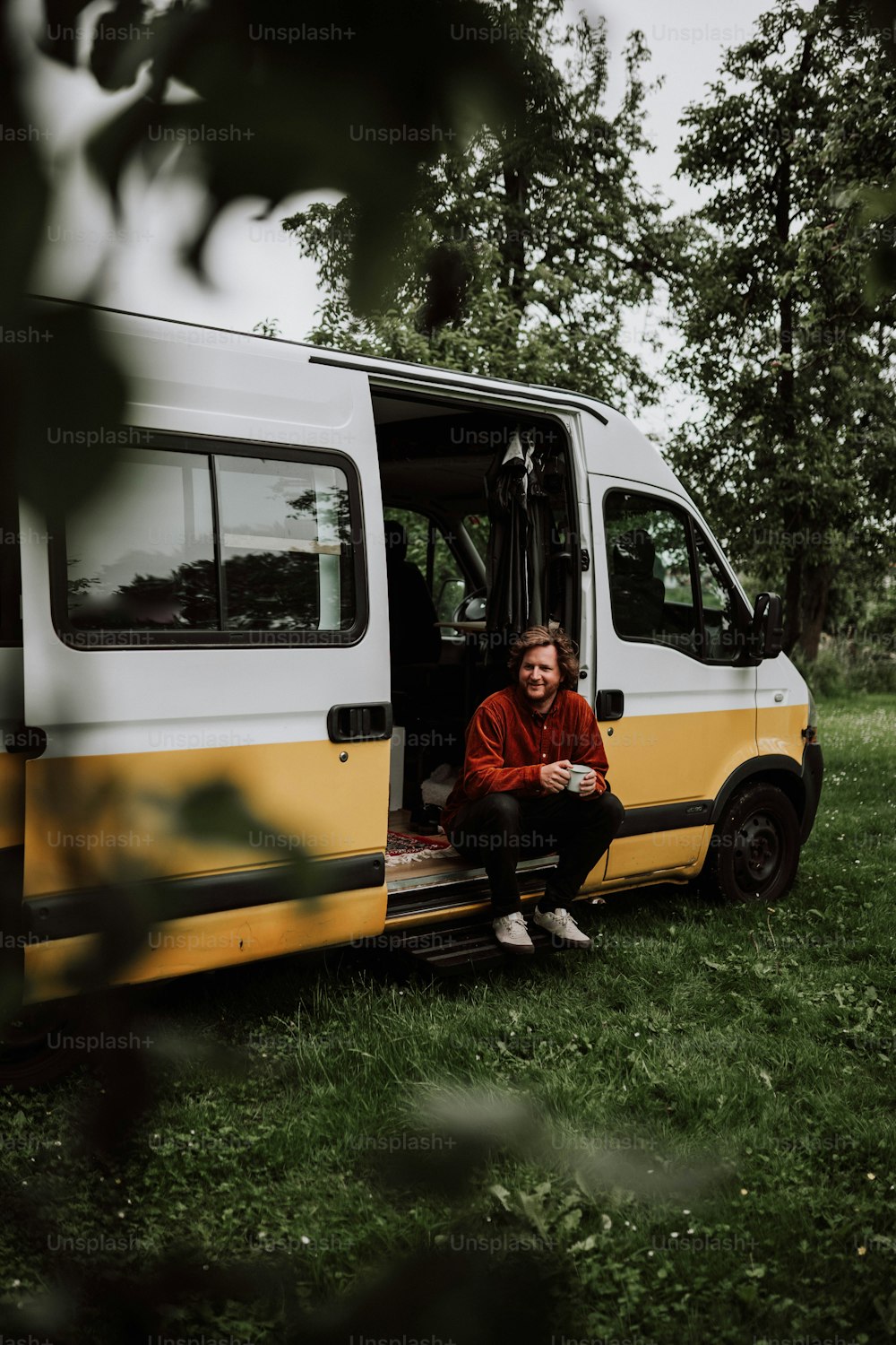 a man sitting in the door of a van