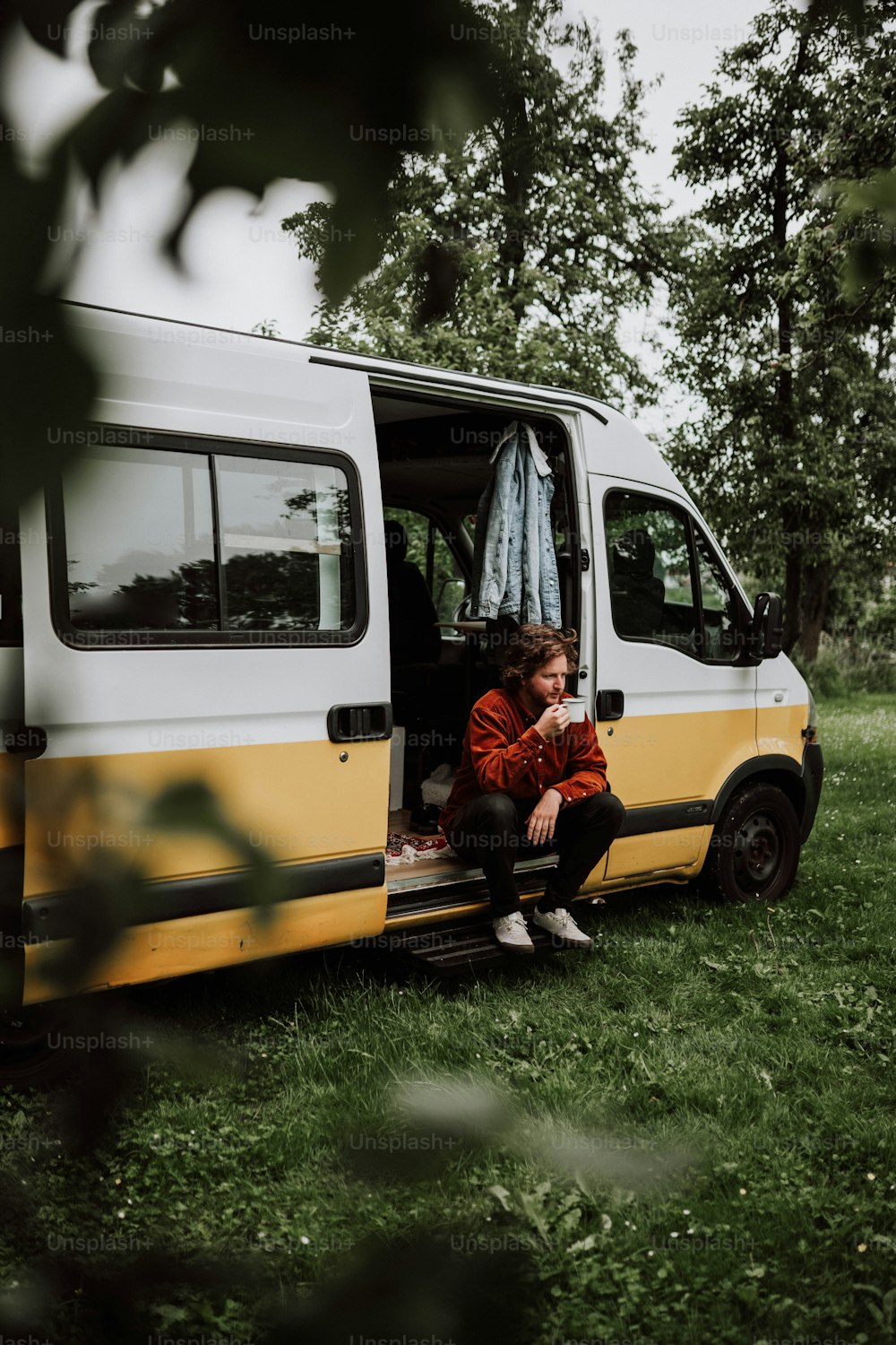 a person sitting in the open door of a van