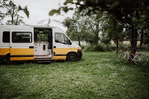 a yellow and white bus parked in the grass
