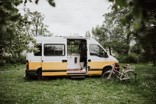 a yellow and white van parked next to a bike