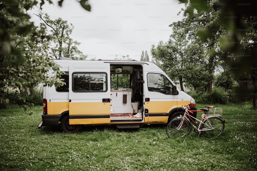a yellow and white van parked next to a bike