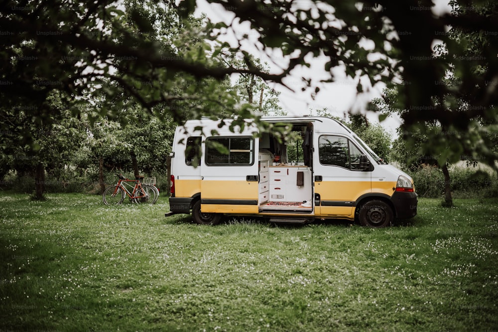 a yellow and white van is parked in the grass