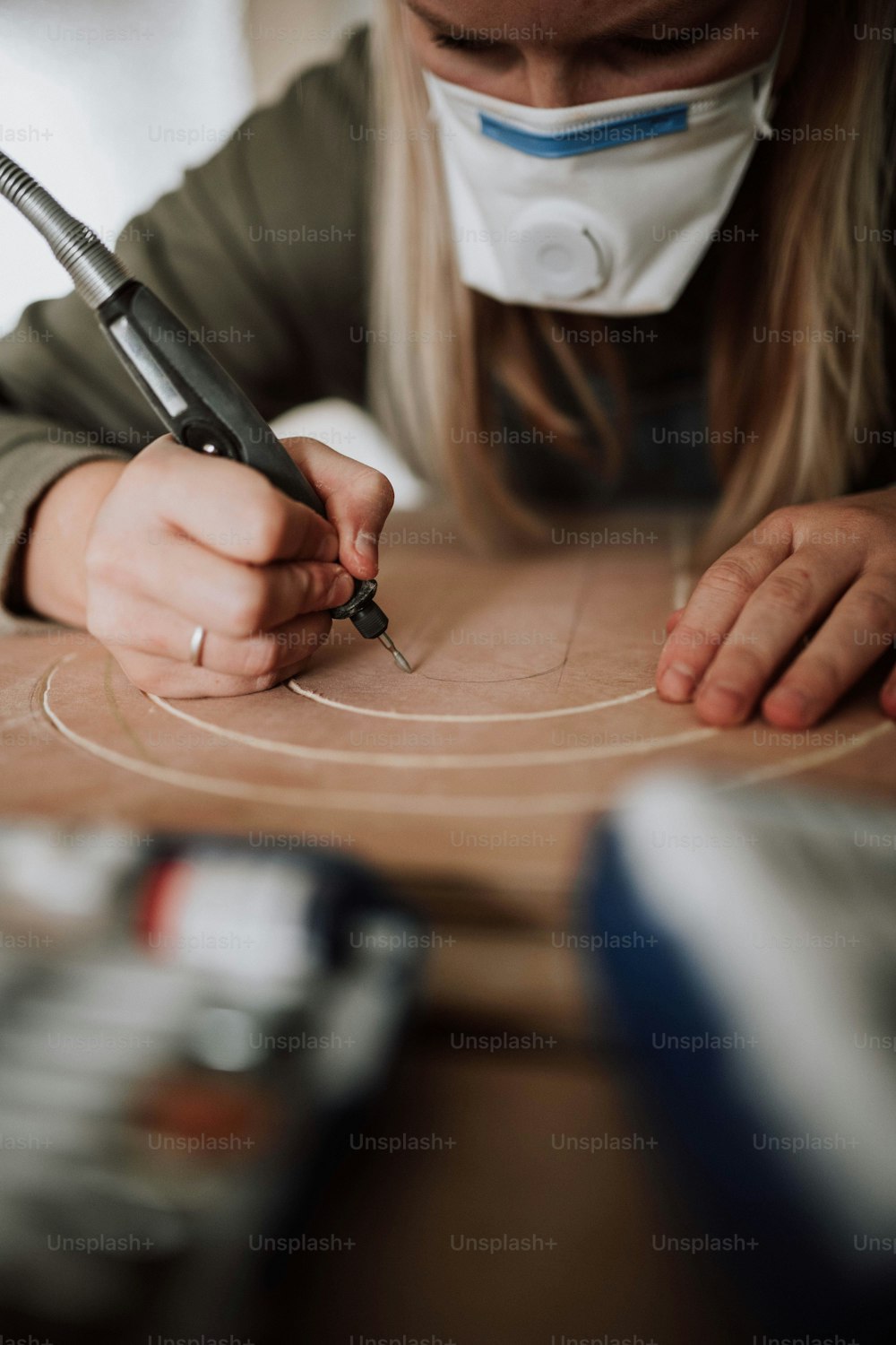 a woman is making a piece of wood with a pair of scissors