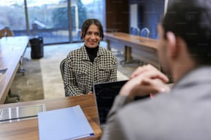 a woman sitting at a desk with a laptop computer