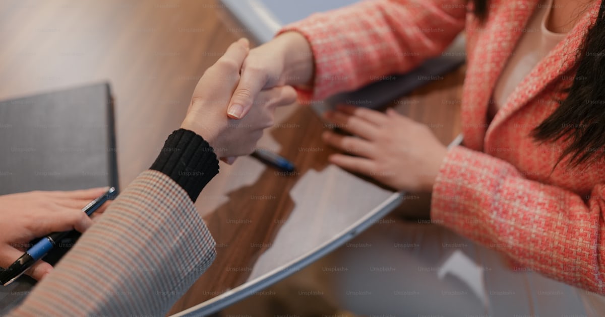 Foto Dos personas dándose la mano sobre un escritorio con una ...