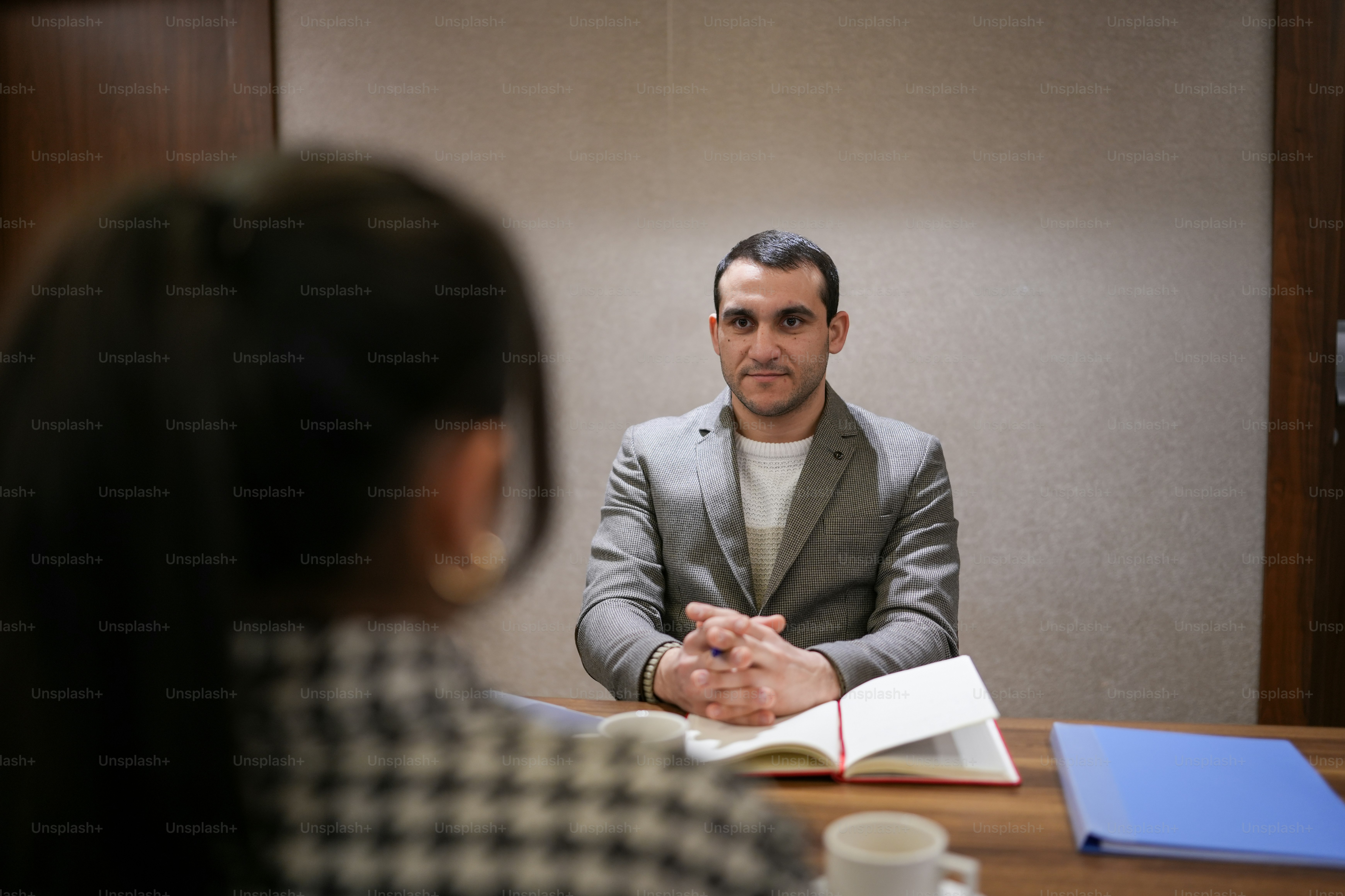 a man sitting at a table with a book in front of him