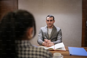 a man sitting at a table with a book in front of him