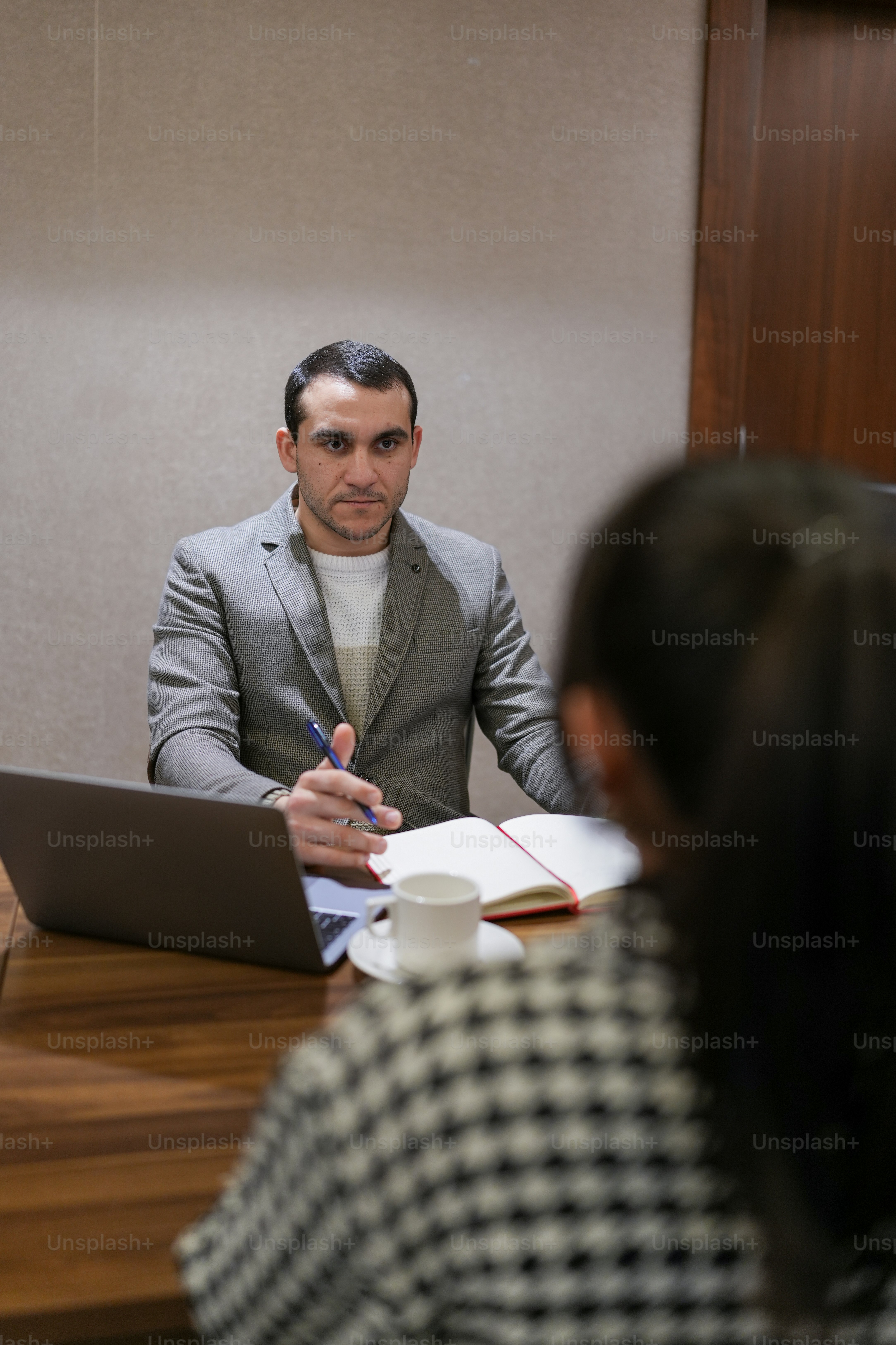 a man sitting at a table in front of a laptop computer