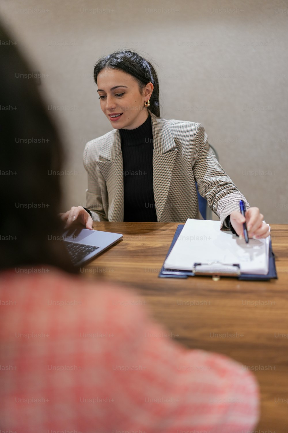 una donna seduta a un tavolo con un quaderno e una penna