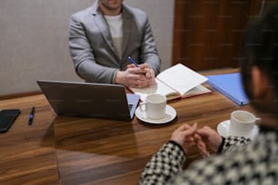 a man and a woman sitting at a table with a laptop