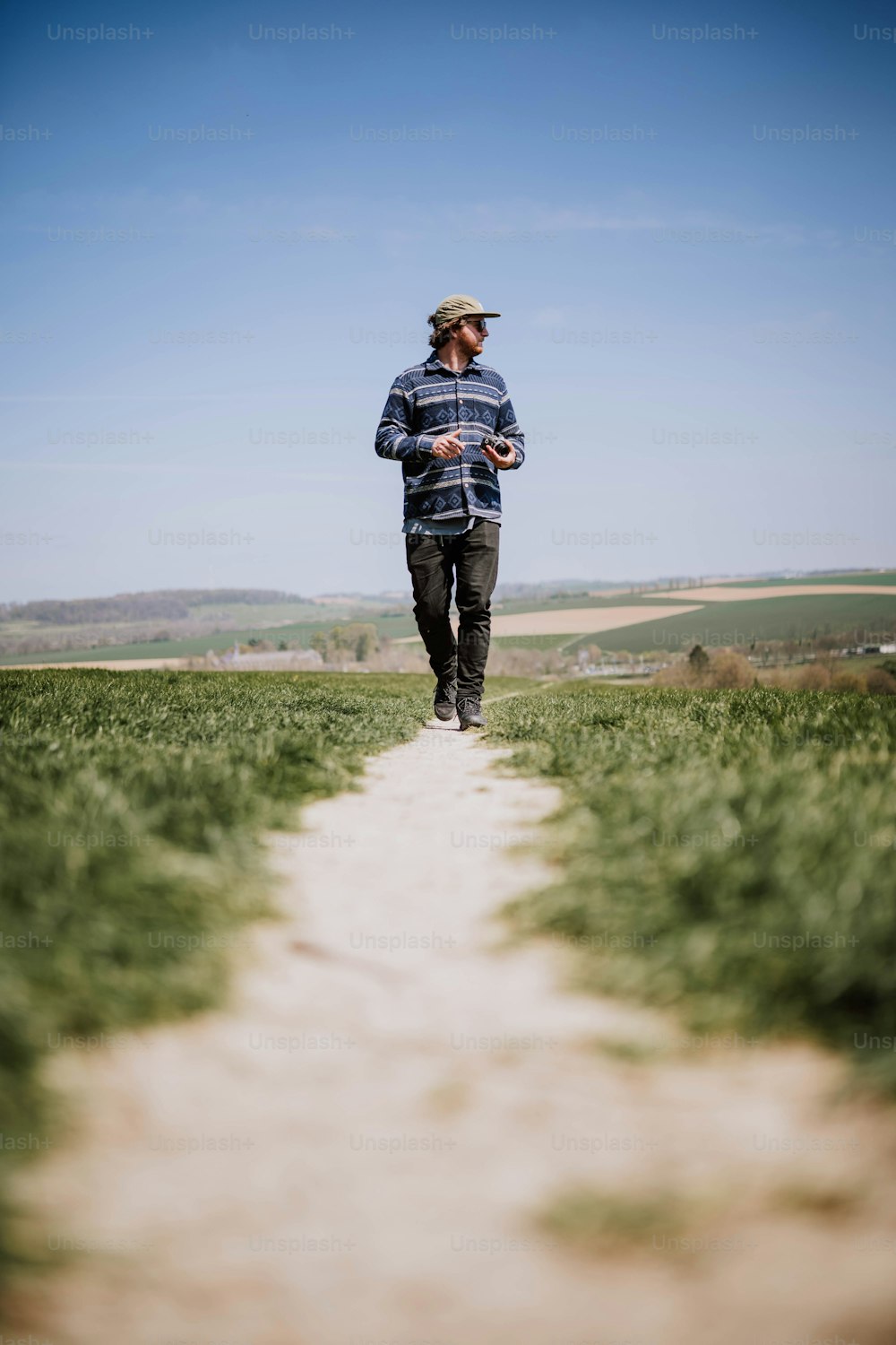 a man is running down a path in a field