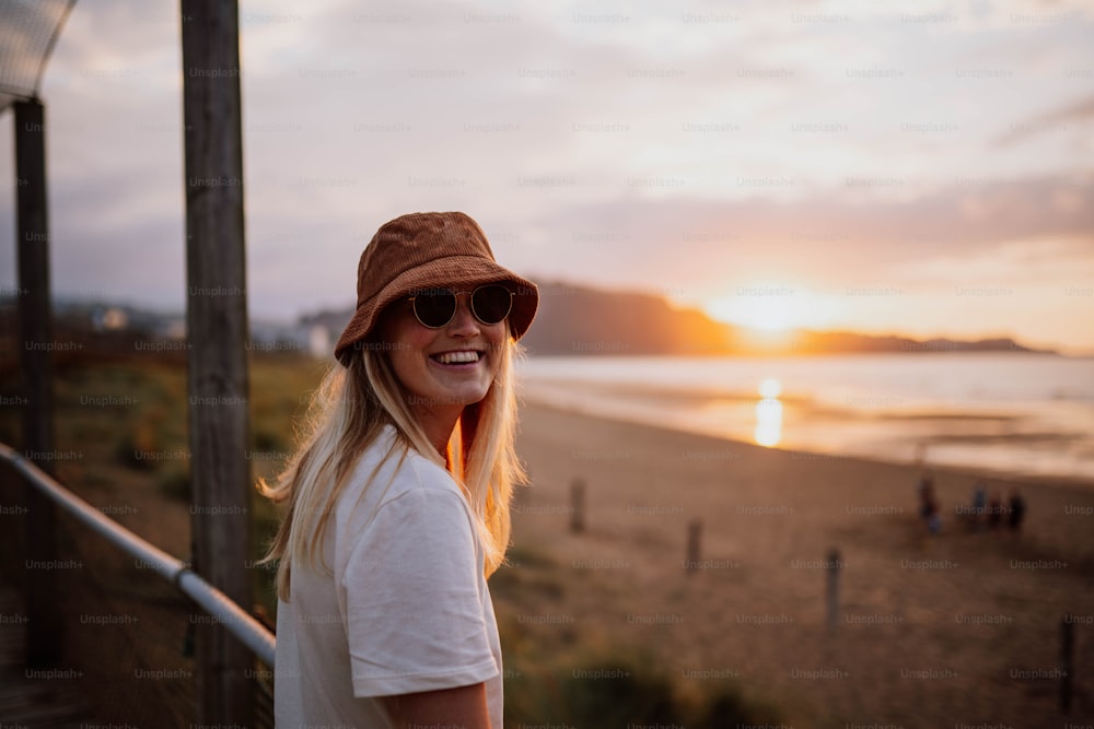 Una mujer con sombrero y gafas de sol en una playa