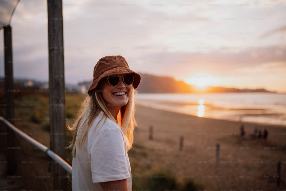 una donna che indossa un cappello e occhiali da sole su una spiaggia