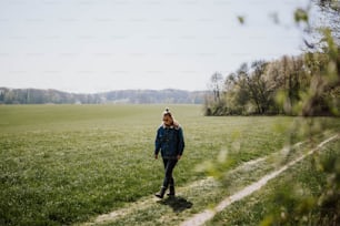 uma mulher em pé em um campo de grama verde