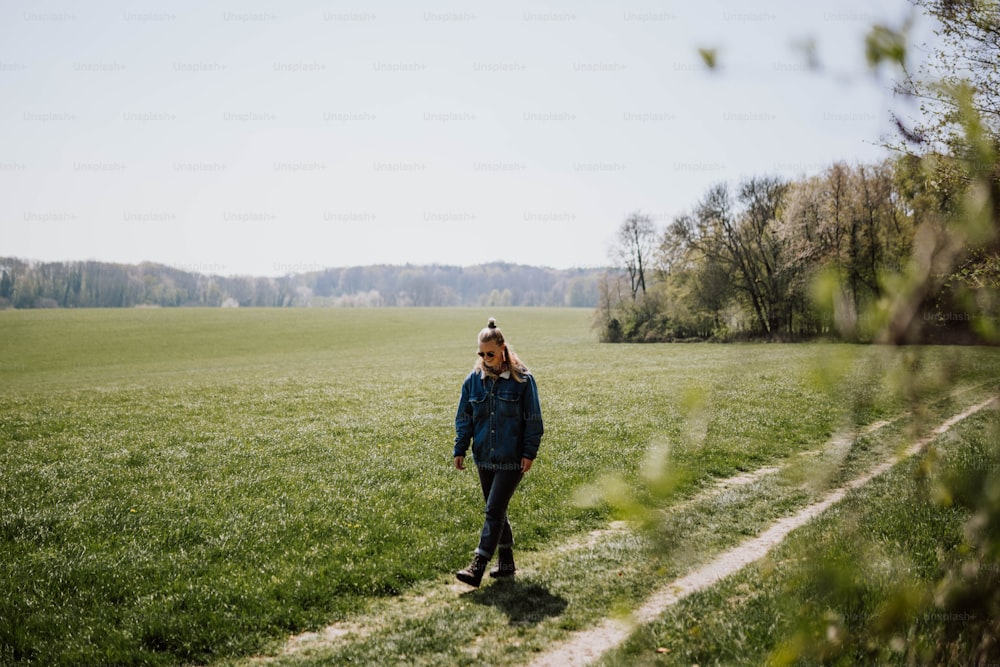 Eine Frau steht auf einem Feld mit grünem Gras