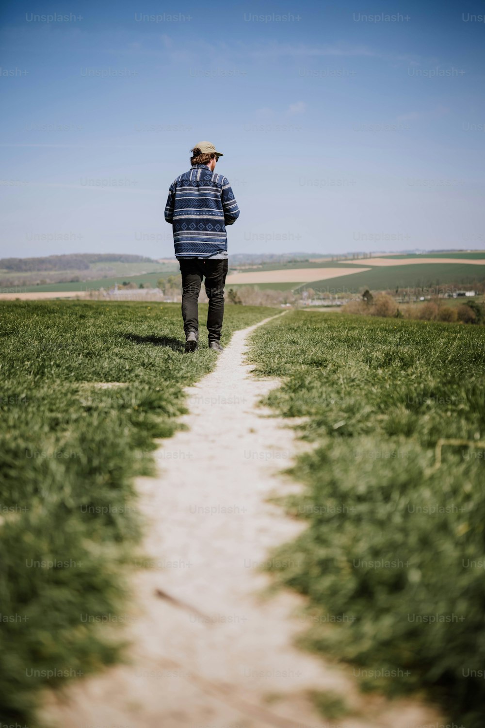 a man walking down a path in a field