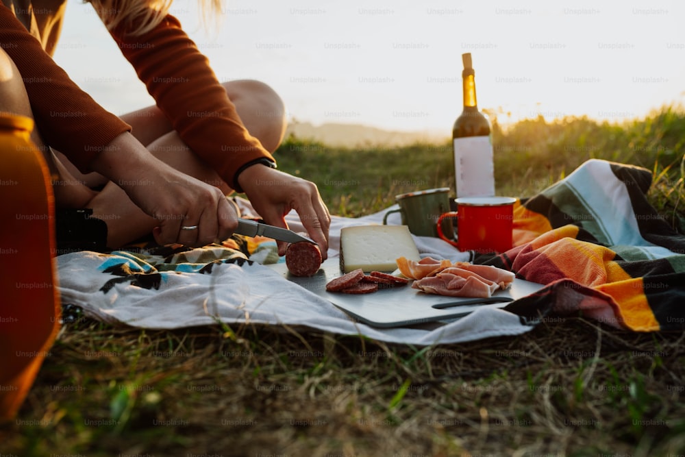 a woman sitting on the ground cutting up food