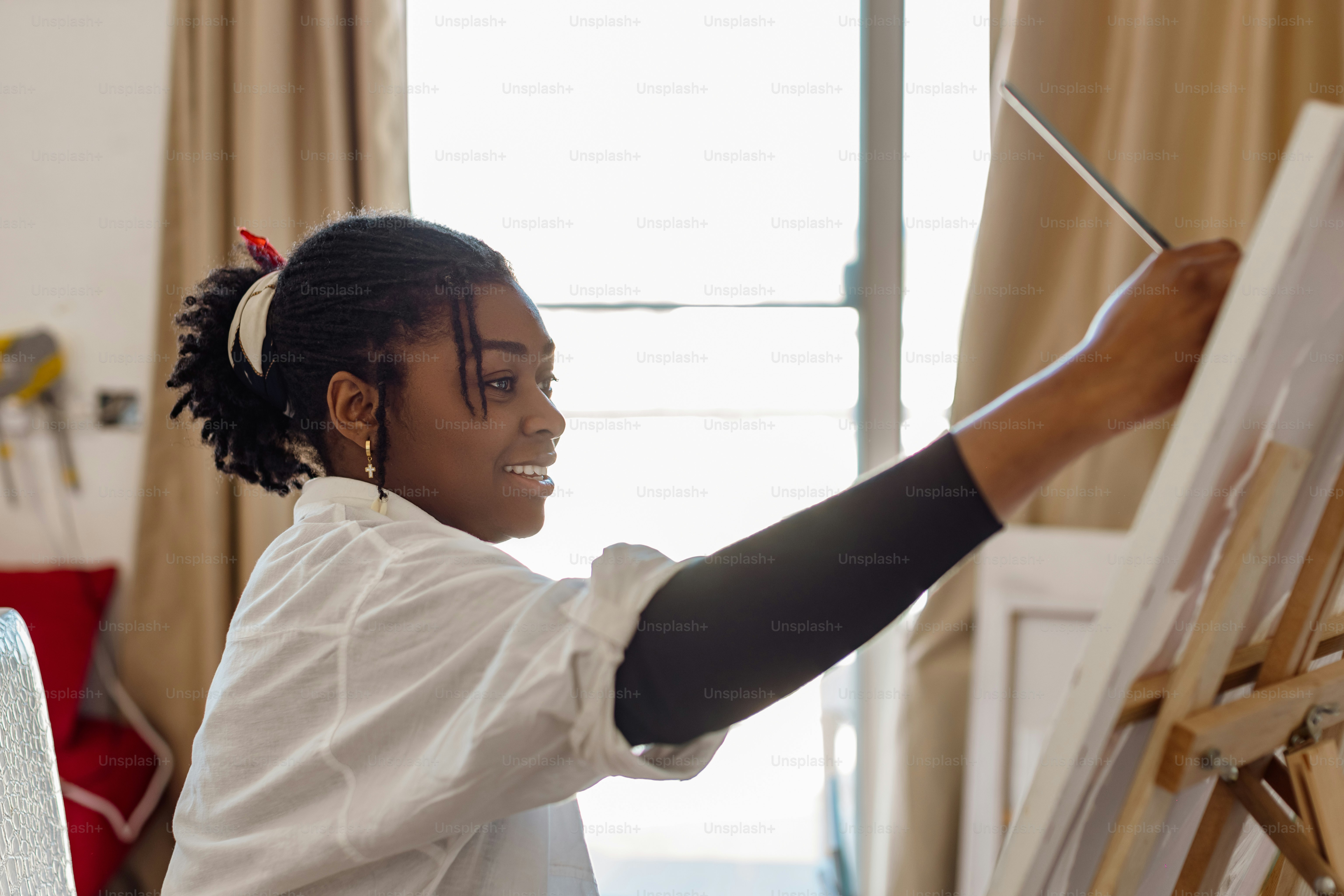 a young girl is painting on a easel