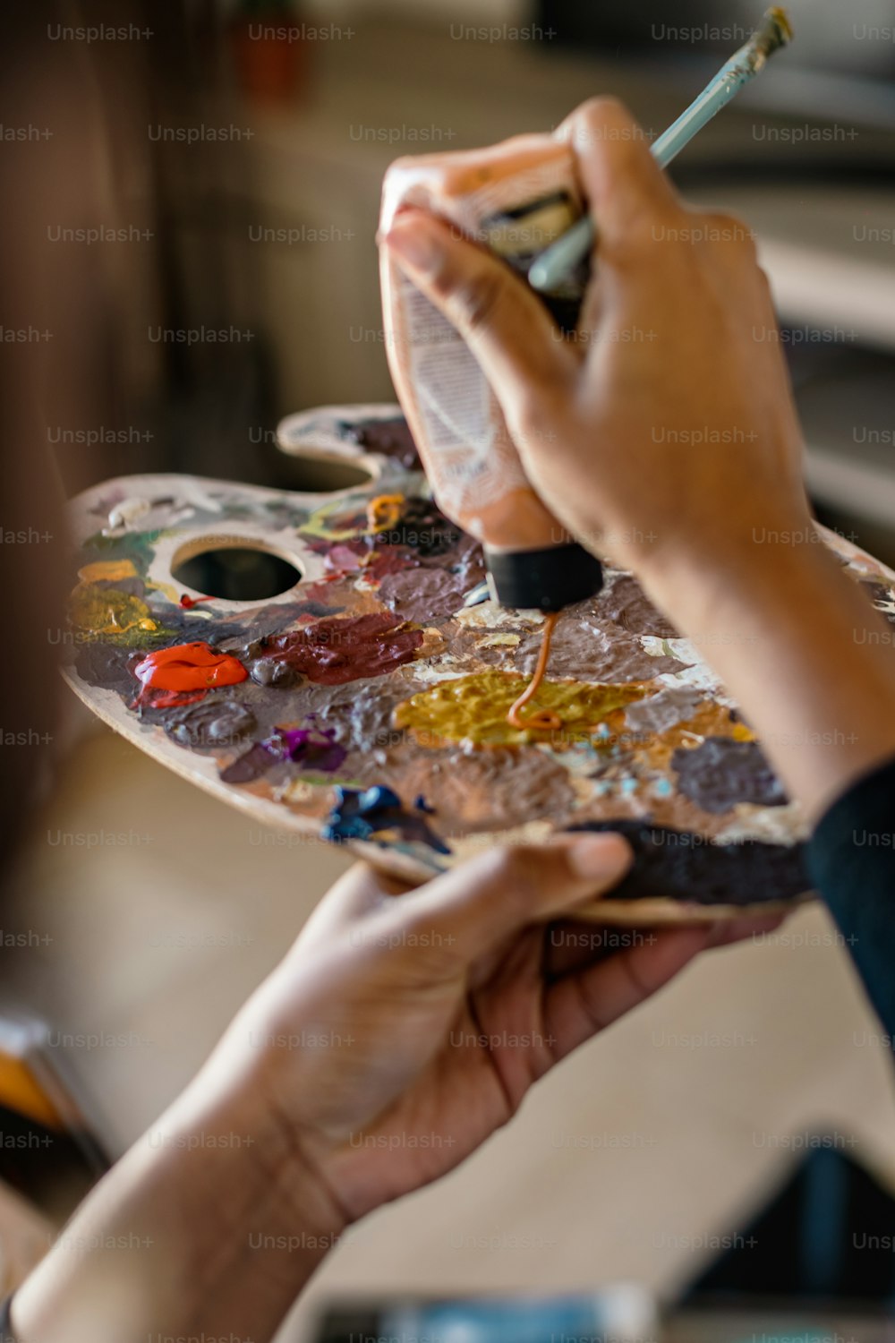 a person holding a paintbrush and a palette