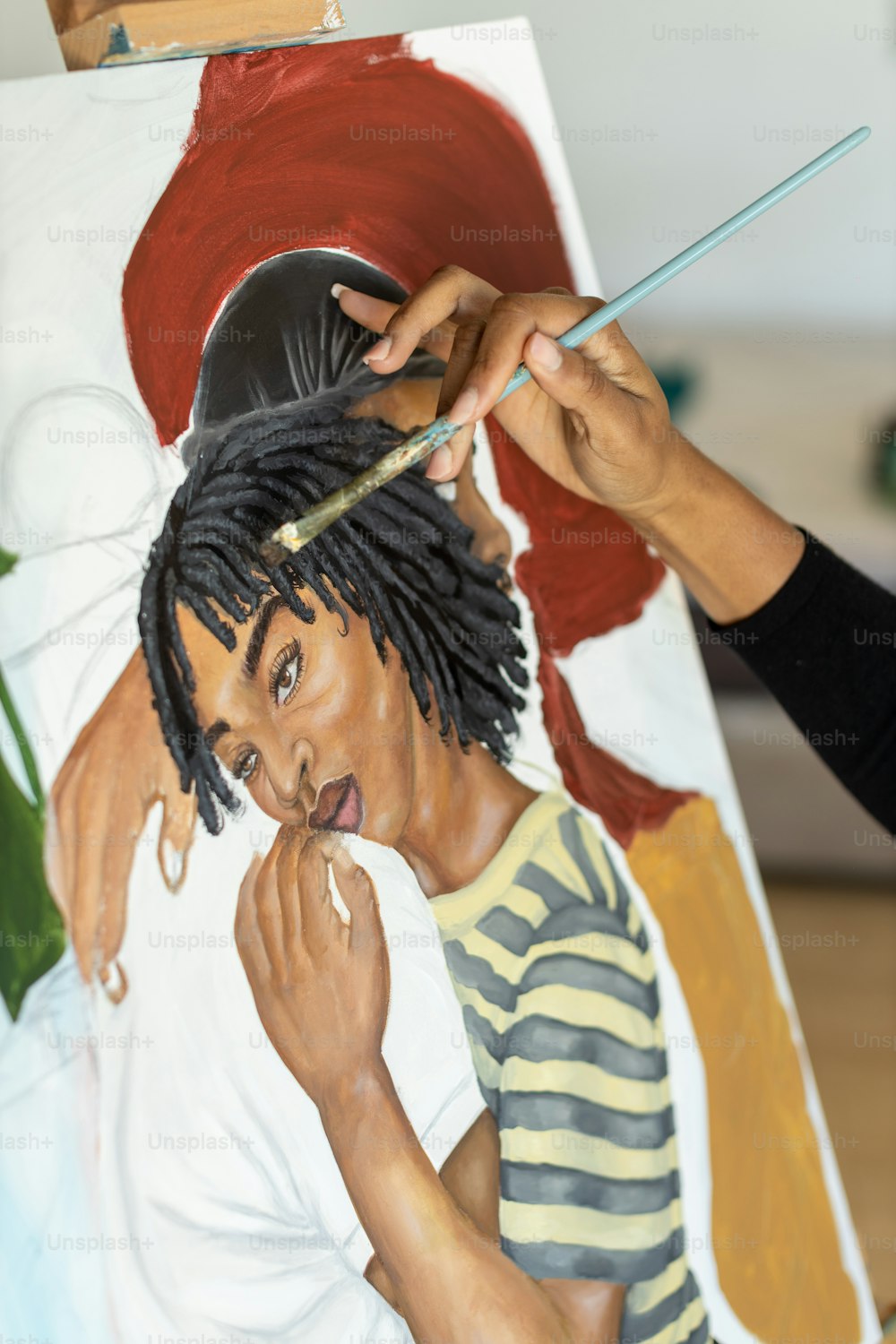 Una mujer está pintando un cuadro de un hombre con rastas