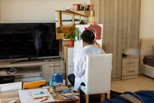 uma mulher sentada em uma cadeira na frente de uma tv