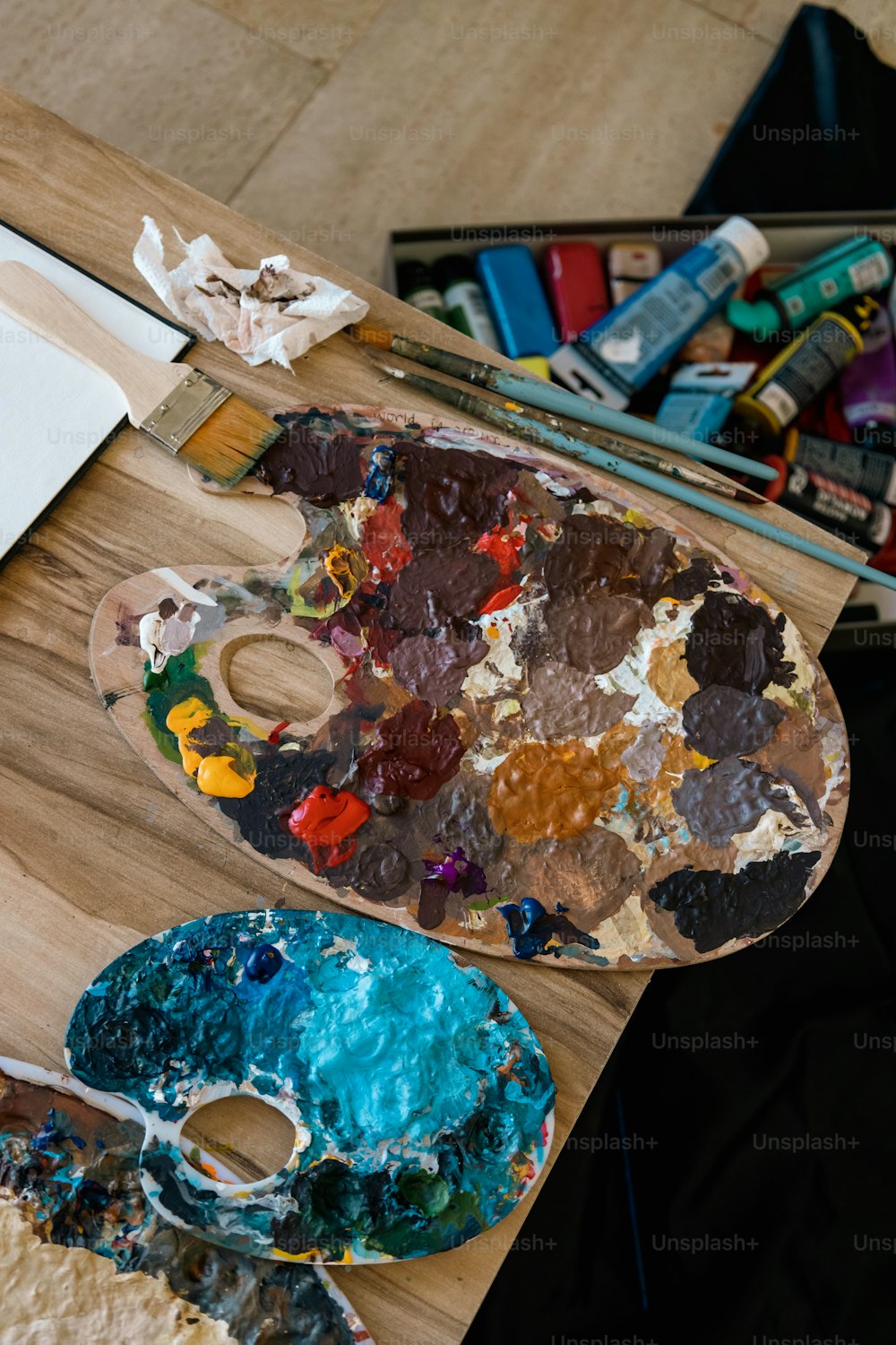 a wooden table topped with a palette of paint