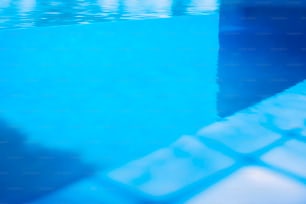 a blue swimming pool with a tiled floor