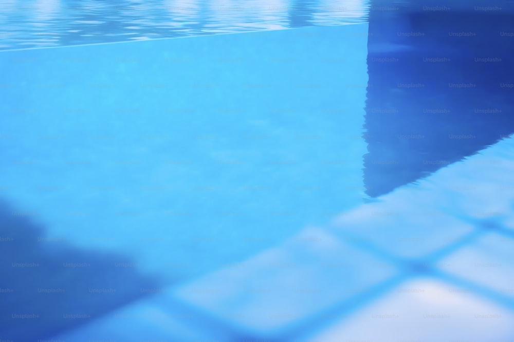 a blue swimming pool with a tiled floor