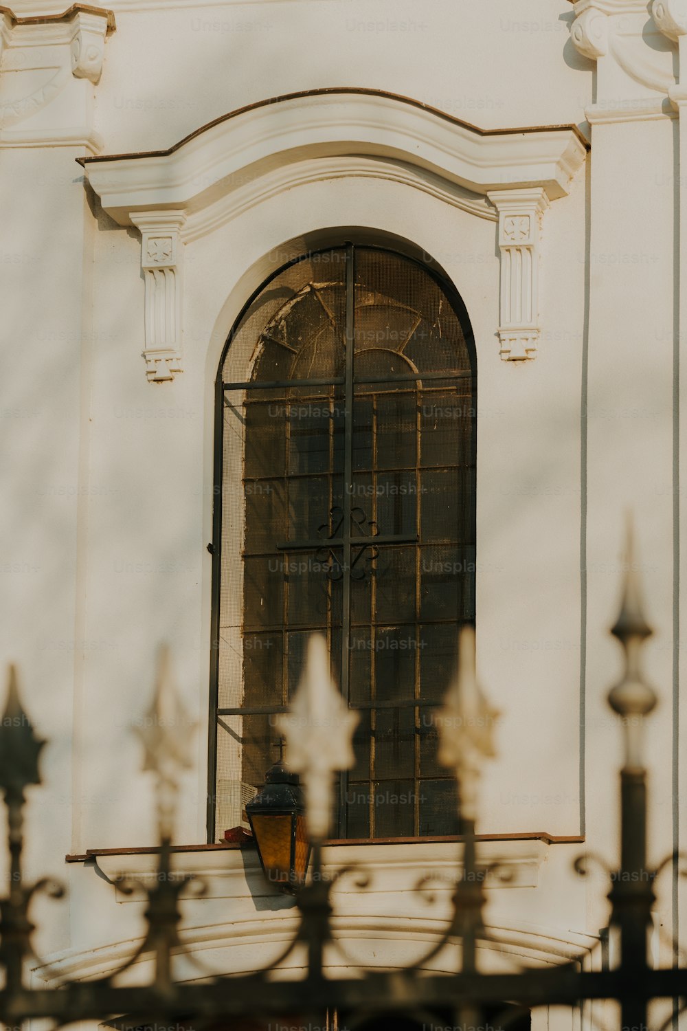 a building with a window and a wrought iron fence