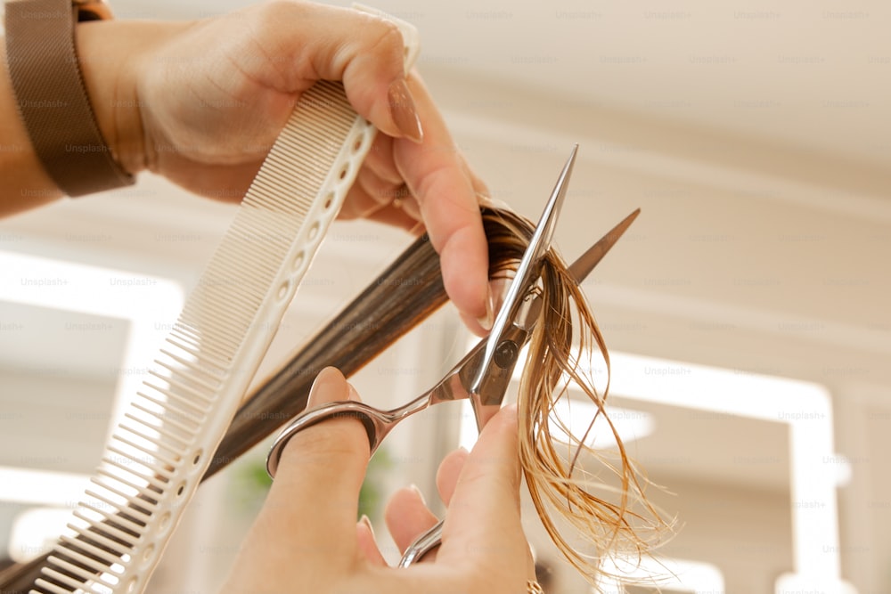 a woman is cutting her hair with a pair of scissors