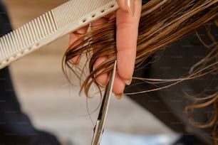a person cutting their hair with a pair of scissors